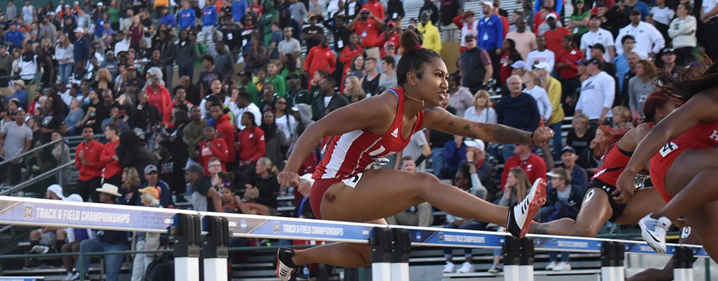 UIW track and field runner jumps a hurdle at a track meet