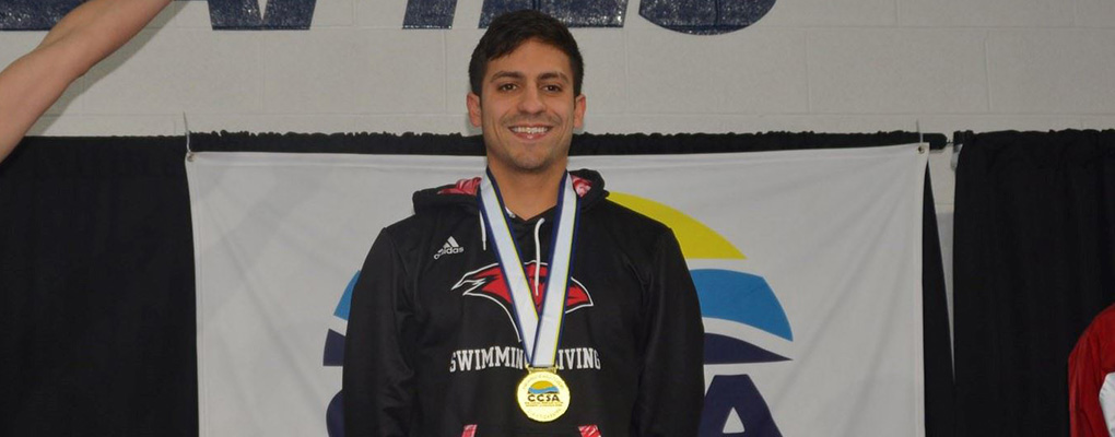 Aaron Moran poses for a photo at a swimming event with his gold medal