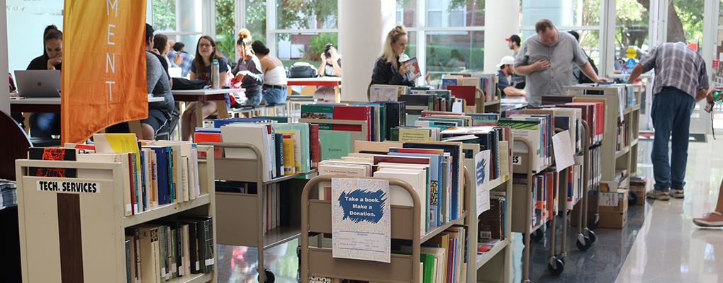 rows of books line the student engagement center and people browse through the items