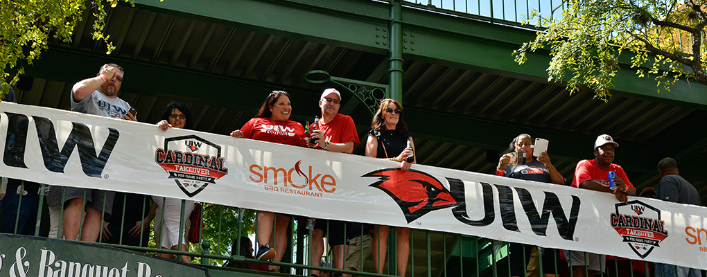 UIW fans look over a balcony, smiling