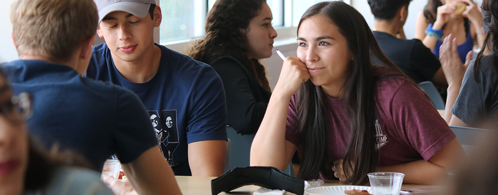 UIW students sit side by side at a table