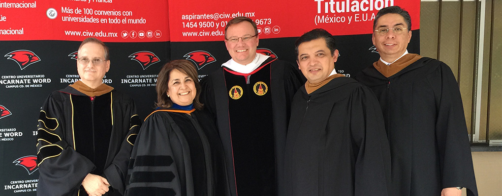 Dr. Evans and Dr. Barbara Naranjo pose for a photo with faculty and staff of CUIW at their commencement ceremony