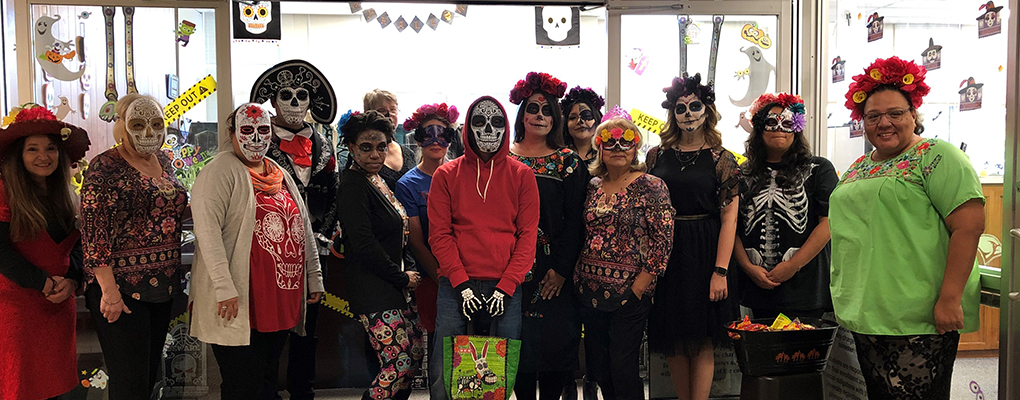 UIW community members dressed in Halloween costumes pose for a photo together