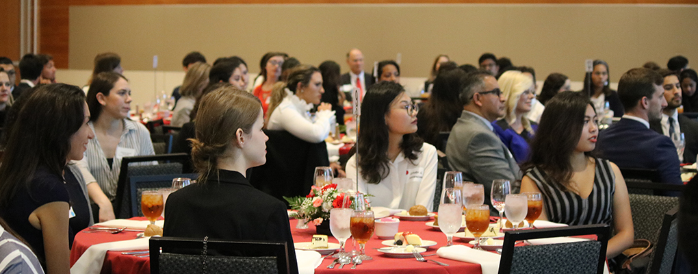 Students sit at a dinner table