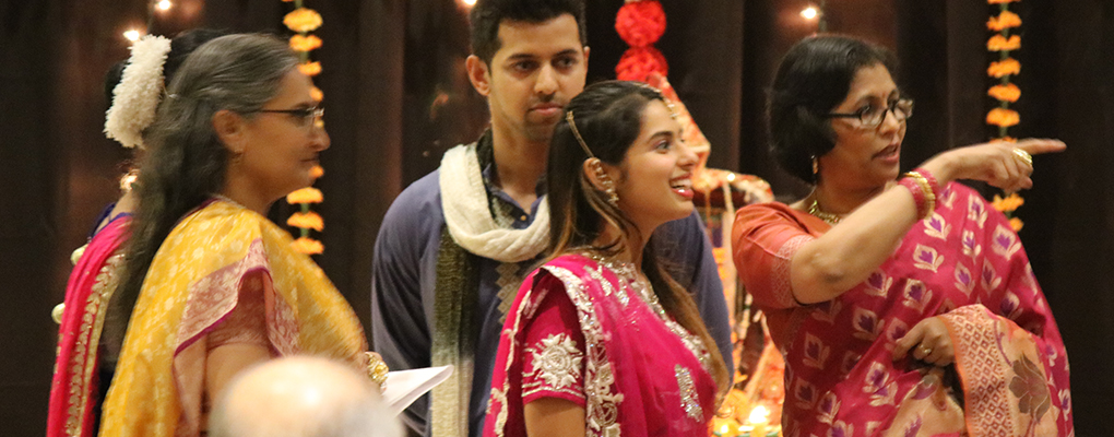 Women dressed in traditional South Asian attire smile