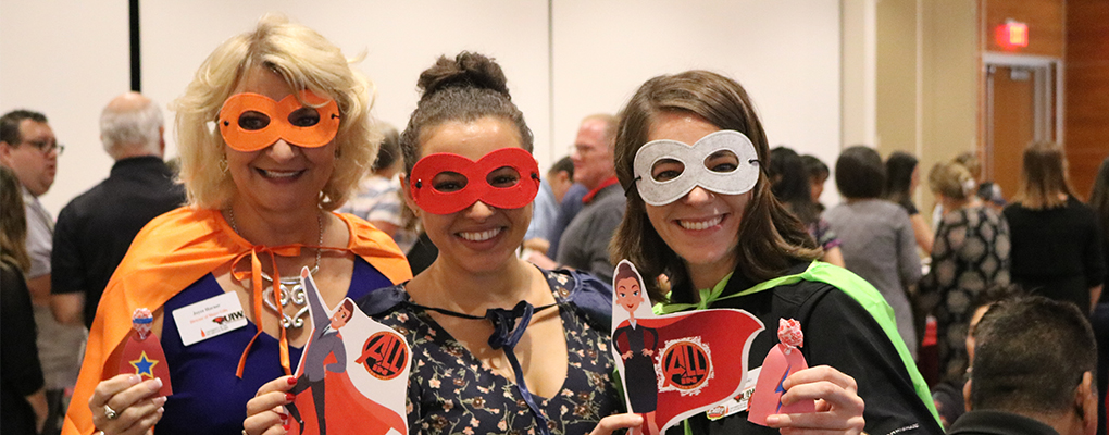 UIW employees pose for a photo wearing superhero masks and capes