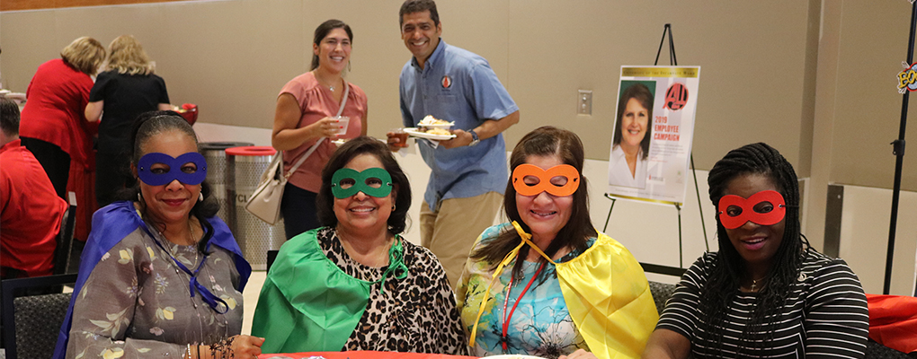 UIW employees pose for a photo wearing superhero masks and capes