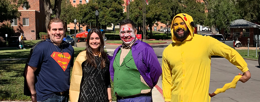 UIW community members dressed in Halloween costumes pose for a photo together