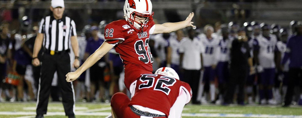 A UIW football player kicks the ball on the field