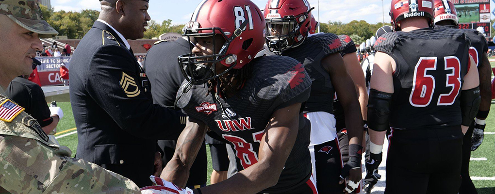 UIW football players shake hands of UIW military and veterans