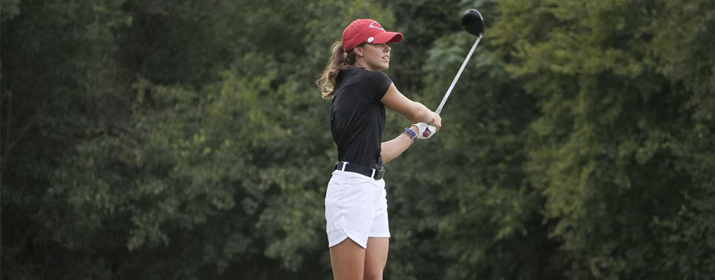 A women's golf player holds her golf club 