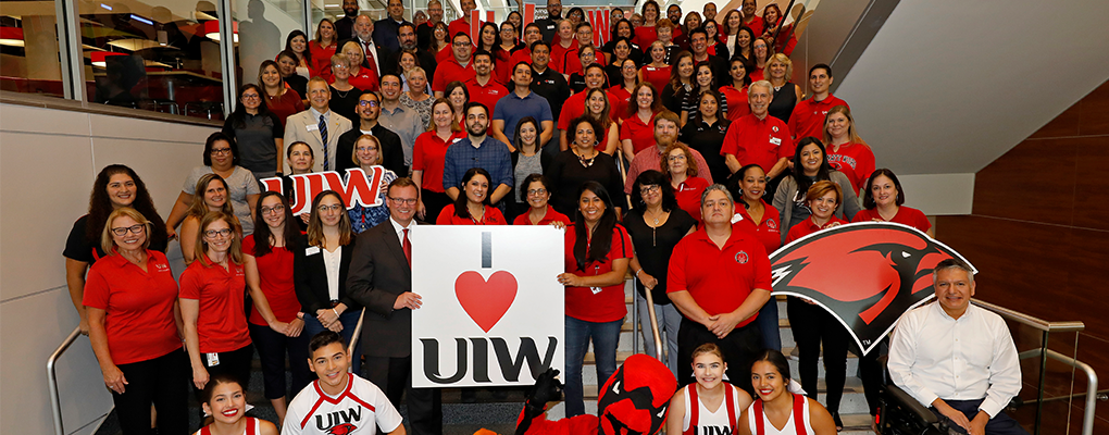 UIW staff members pose for a group photos on a set of stairs.