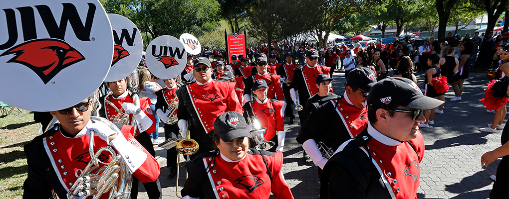 The UIW Marching Band marches in uniform holding their instruments