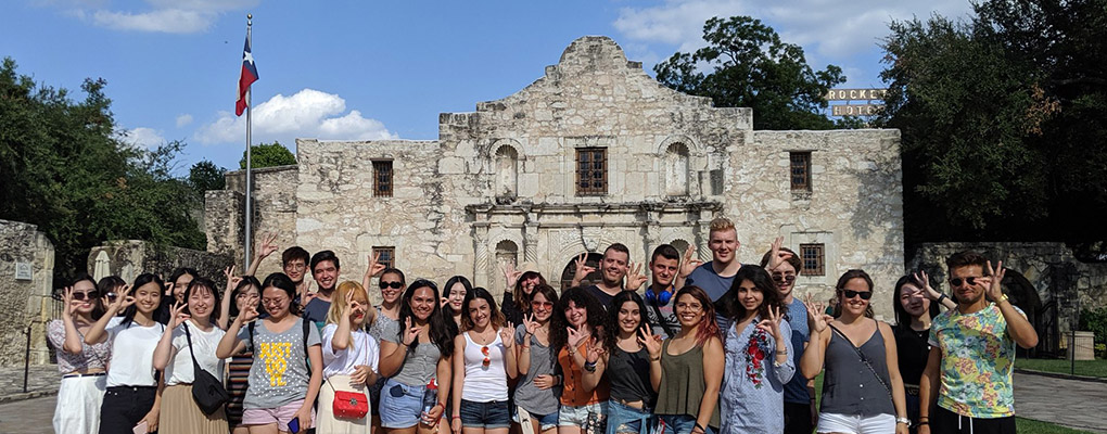 UIW international students pose for a photo in front of The Alamo