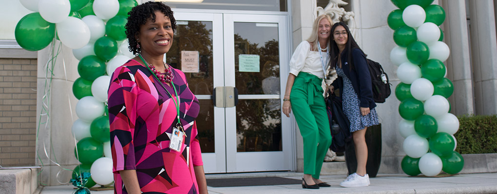 Incarnate Word High School administrators stand outside the front of campus, ready to greet students 