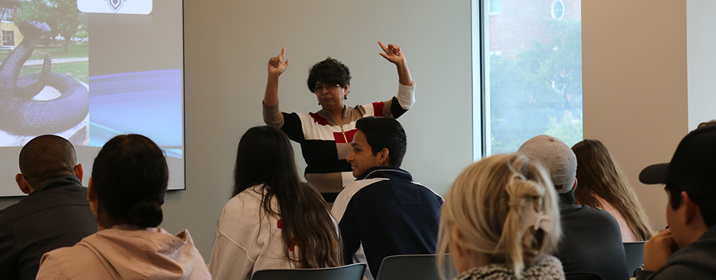 A UIW faculty member delivers a presentation to students sitting in a classroom