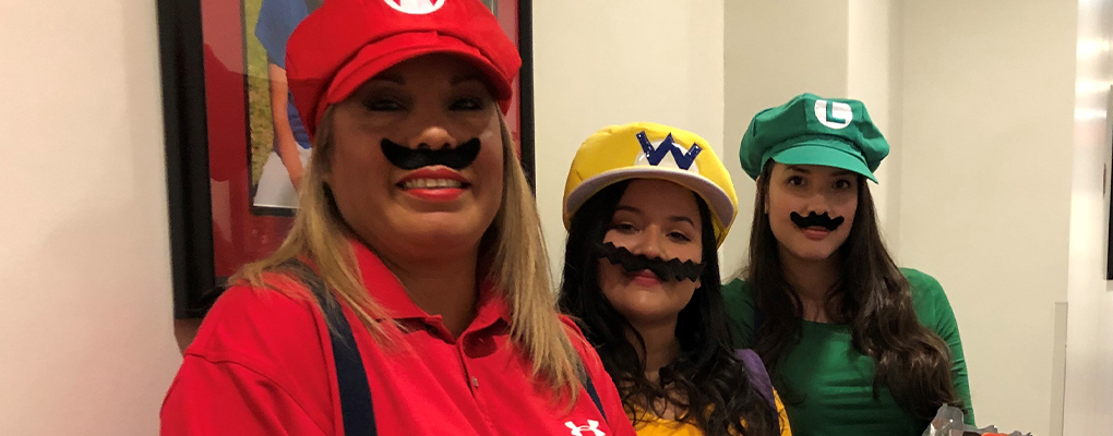 UIW community members dressed in Halloween costumes pose for a photo together