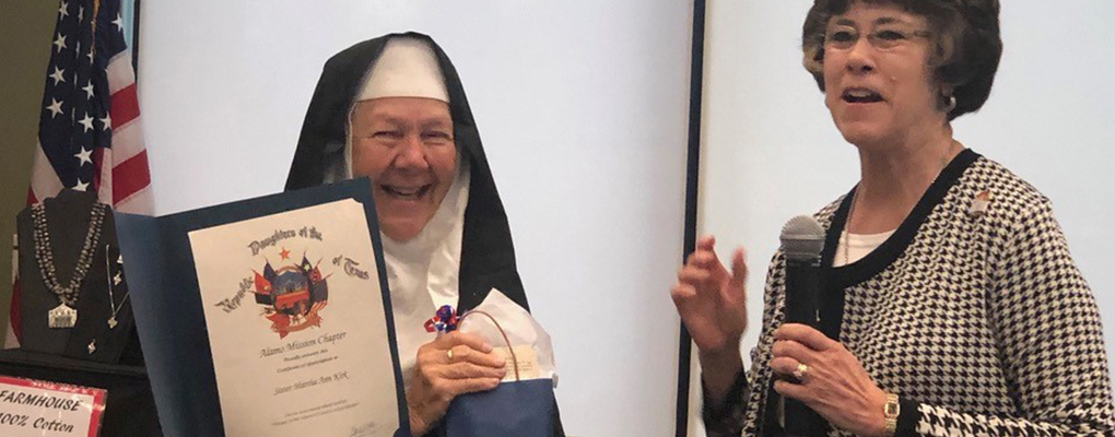 Sr. Martha Ann smiles as she receives a certificate