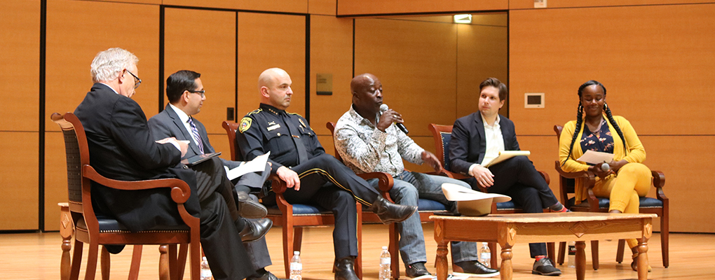 A panel of speakers sits on stage and carries a discussion