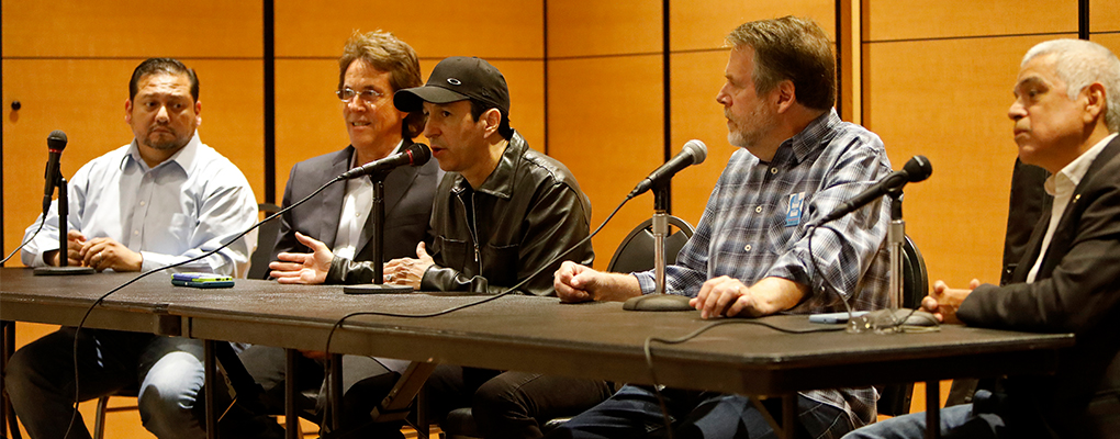 Music industry professionals sit behind a table for a panel discussion