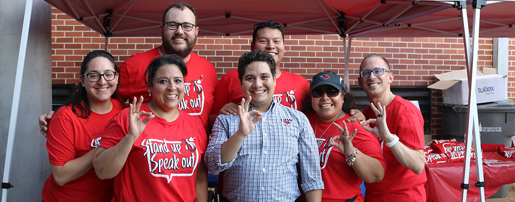 A group of UIW employees stand together for a photo and smile at the camera