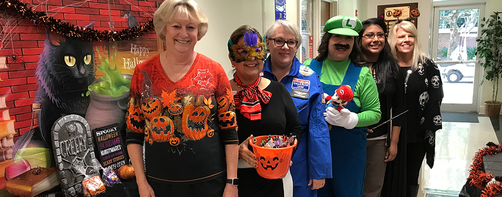 UIW community members dressed in Halloween costumes pose for a photo together