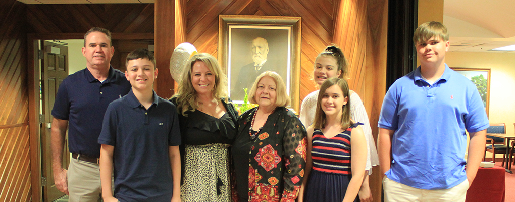 Roslyn Grimes poses for a photo with her family at her retirement celebration