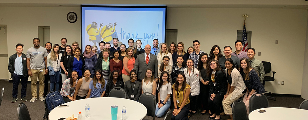 A group of students pose for a photo with Dr. Paul Freeman