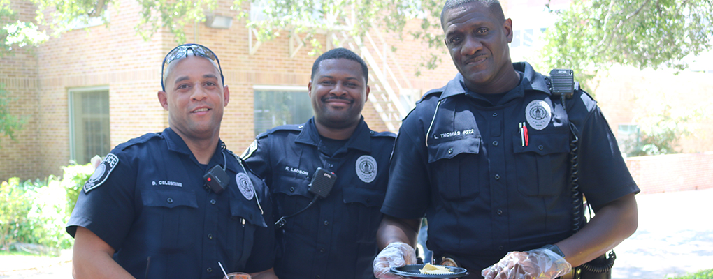 UIW police officers pose for a photo holding a plate of chips and salsa