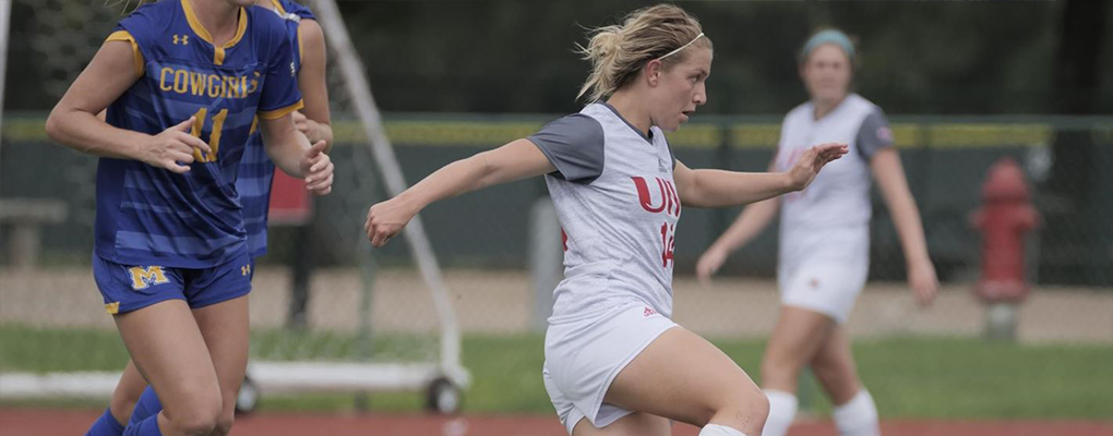 A women's soccer player runs down the field