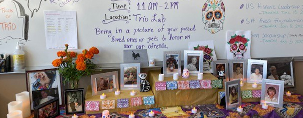 An ofrenda for Dia de los Muertos with photos, candles and traditional decorations