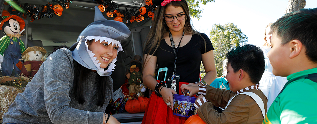 A woman dressed as a shark passes out candy to trick-or-treaters