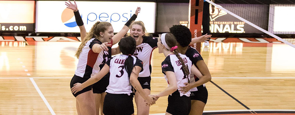 UIW volleyball players gather in a celebratory huddle 