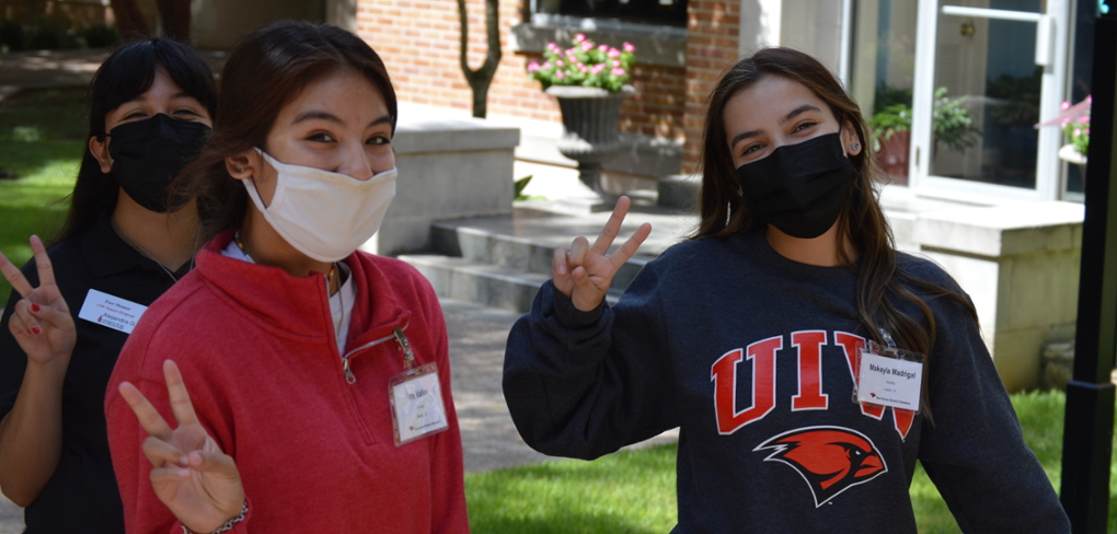 Students smiling and waving the peace sign