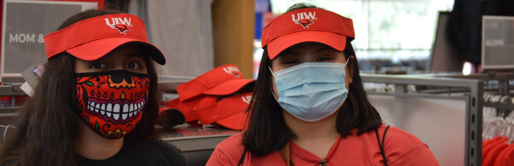 Two students wearing hats and masks