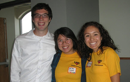 three students standing together and smiling