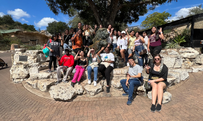 Group of students by the statue of a lion