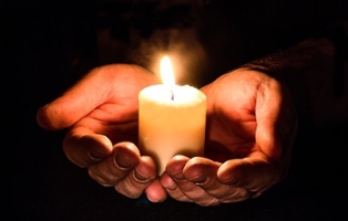 hands holding lit candle
