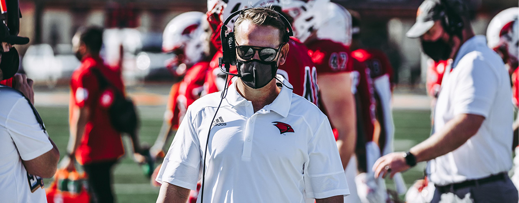 Coach Morris walks on the sidelines during a football game