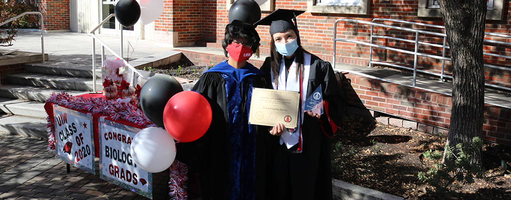Biology students holding award and wearing masks