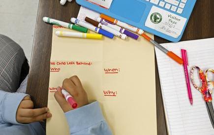 A student writes with markers