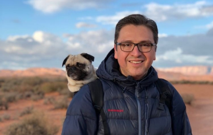 Jose Moreno with a pug looking over his shoulder