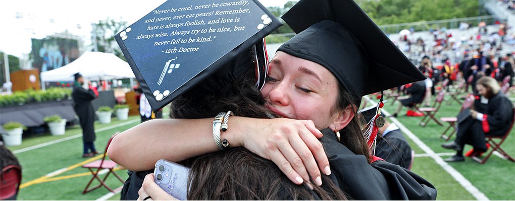 Two graduates embracing