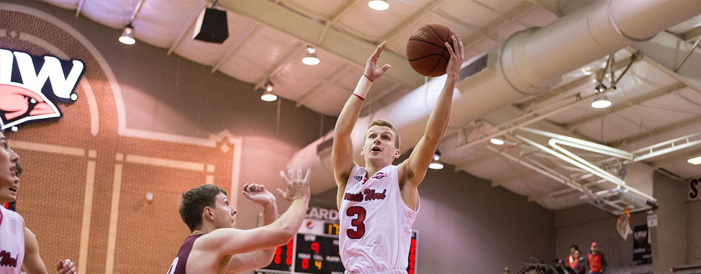 UIW basketball player reaches for basket 