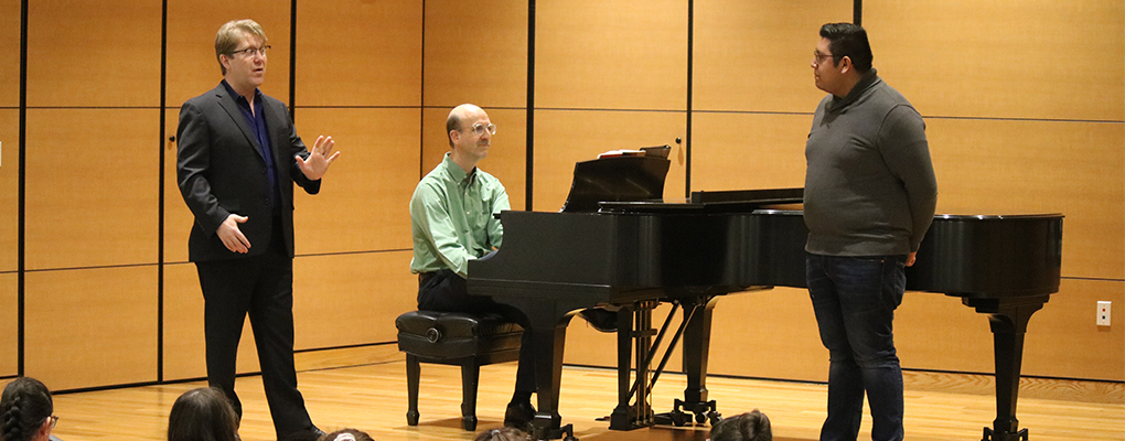 A students performs on stage and receives feedback from Daniel Belcher