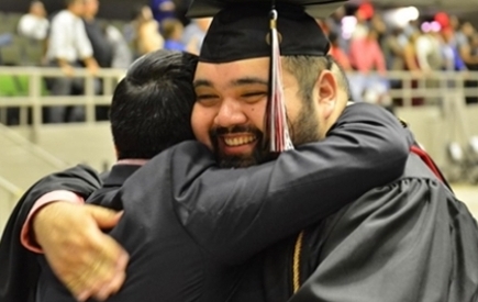 A graduate hugs someone