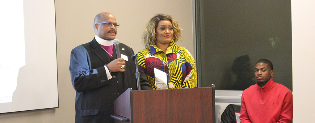 A man and woman stand behind a podium