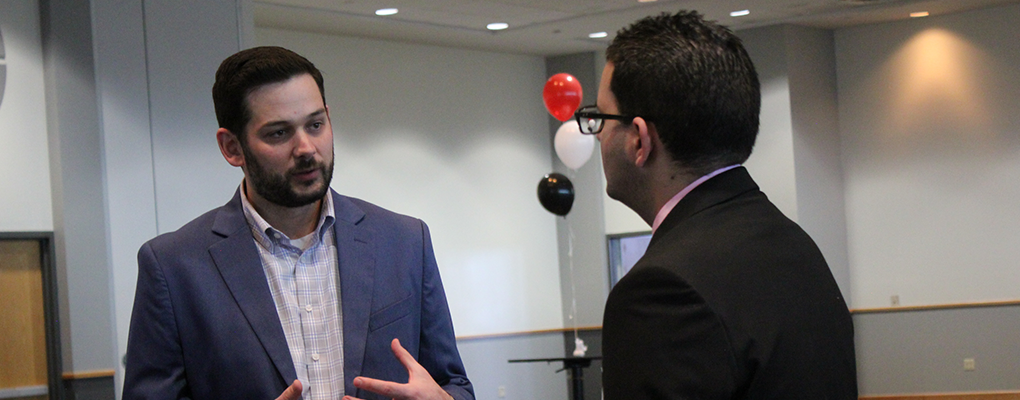 Two men converse at a career fair