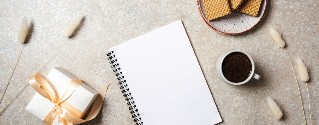 A table laid with coffee and a notebook