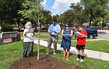 The Evans family and Sr. Martha Ann read a prayer as they surround a tree